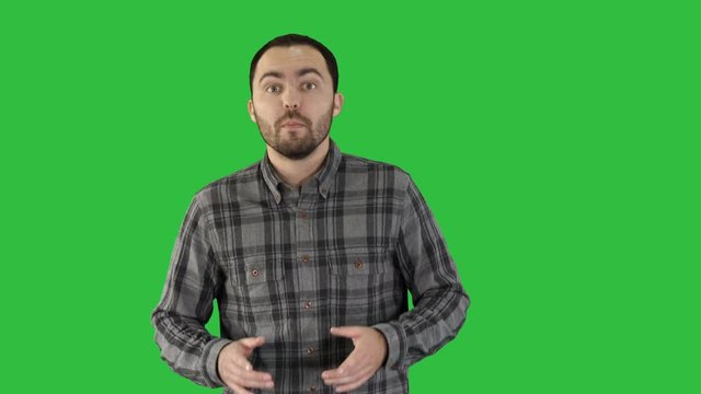 Man in casual walking and talking to the camera on a Green Screen, Chroma Key.