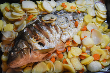 Carp baked in pots with potatoes and onions. Baked fish