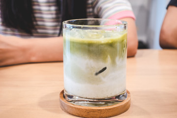 Ice matcha latte on a wooden table.