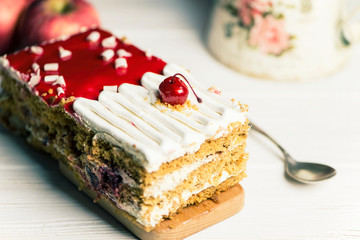 delicious cherry sponge cake with white cream and red jelly