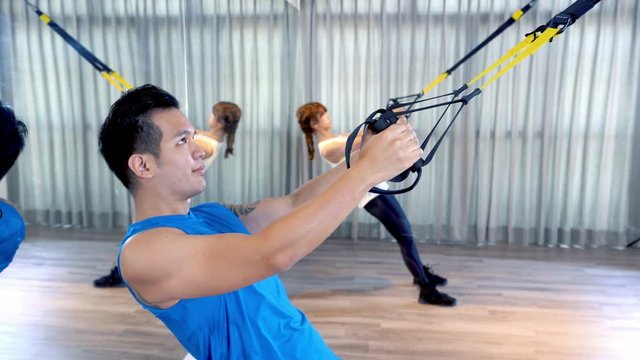fitness people workout with trx straps.