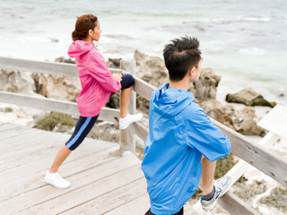 Young couple at the seaside doing exercises