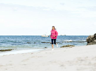 Young Woman Jogging On The Beach