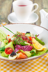 A delicious smoked salmon garden salad with smoked salmon, mixed baby greens
