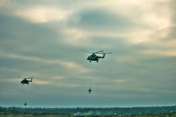 military army helicopter transporting an artillery piece.