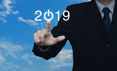 Businessman pressing 2019 start up business icon over blue sky with white clouds, Happy new year 2019 cover concept