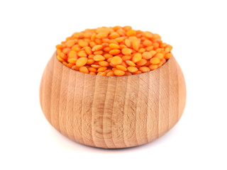 Red lentils in the wooden bowl isolated on white backgroun