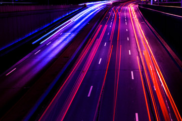 Cars light trails on a curved highway at night. Night traffic trails. Motion blur. Night city road...