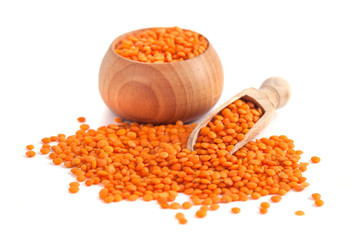 Red lentils in the wooden spoon and bowl, isolated on white background