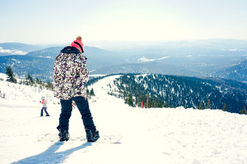 Beautiful amazing day winter mountains. A woman rides snowboard. Sport hike in holidays. Landscape inspiring. Cool fun girl. Blue sky and white snow. Happy hobby, active vacation