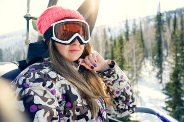 Close-up portrait of woman snowboarder on a cable ski lift in the morning enjoying a beautiful view recreation active sport seasonal concept