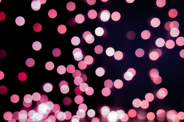Red and pink Christmas tree bokeh on black background of defocused glittering lights, Christmas...