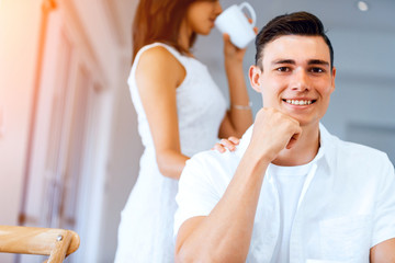 Happy young man with cup of tea or coffee