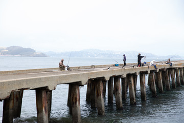 Fototapeta na wymiar pier on the sea people fishing
