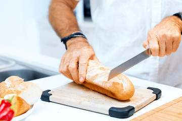 Male hands cutting bread