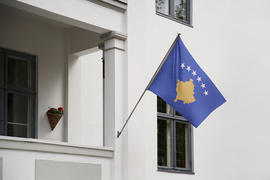 Kosovo Flag Hanging On A Pole In Front Of The House. National Flag Waving On A Home Displaying On A Pole On A Front Door Of A Building And Raised At A Full Staff.