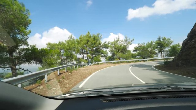 Mountain road view from the car while driving in sunny weather
