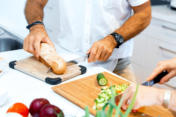 Male hands cutting bread