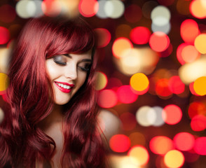 Redhead woman with long curly hairs on bright color party bokeh glitter background