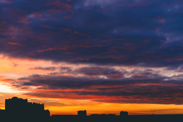 Cityscape with wonderful varicolored vivid fiery dawn. Amazing dramatic multicolored cloudy sky....