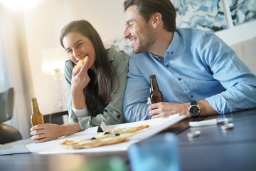  Happy relaxed couple sharing a pizza at home