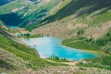 Wonderful three mountain lakes in valley of highlands. Clean azure water surface. Giant rocks and mountains with rich vegetation and coniferous forest. Atmospheric green landscape of majestic nature