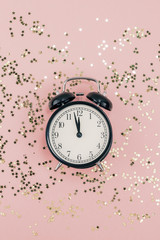 New Year concept. Alarm clock with golden confetti
