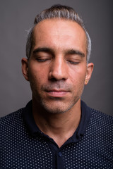 Face of handsome Persian man with gray hair eyes closed