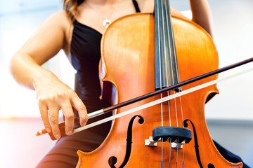 Close up of cello with bow in hands