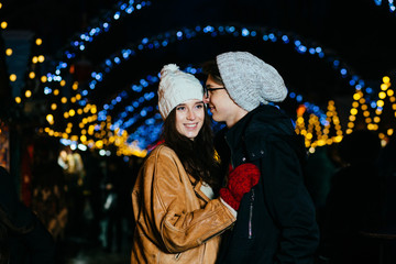 Romantic couple in city at night. Holidays, christmas and people concept.