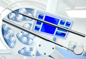 Sonde und Mundspiegel in der Zahnarztpraxis vor Operationslampe