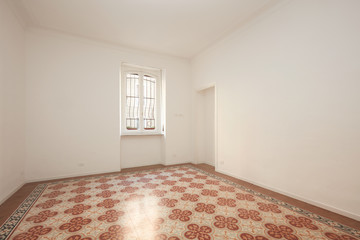 White, empty room with decorated floor in a renovated apartment