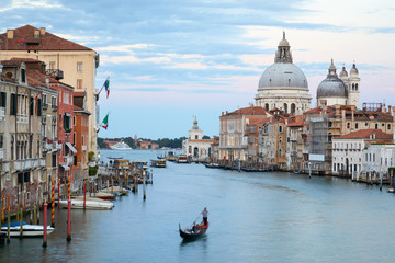 Obraz na płótnie Canvas Grand Canal in Venice with gondola and Saint Mary of Health basilica at dusk in Italy