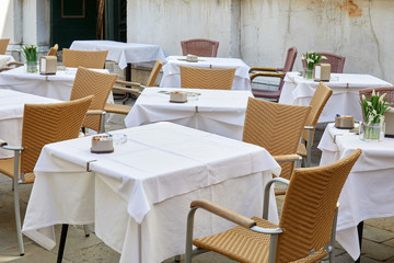 Fototapeta na wymiar Empty sidewalk tables and chairs in a sunny morning