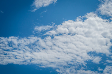 A deep blue sky with continuous white clouds