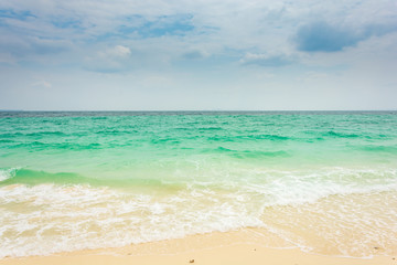 Turquoise color sea in cloudy sky and beautiful sand.