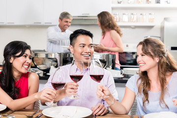 Group of friends holding red wine glass enjoying the party