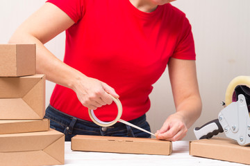 Woman packing cardboard boxes using tape