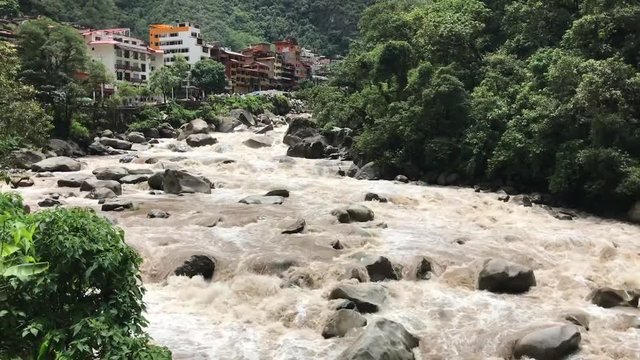 wild Urubamba River in Peru with Aguas Calientes town on backward, panoramic footage with natural sound