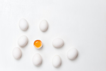 Eggs . One cracked and group of whole unheard eggs on a white background.