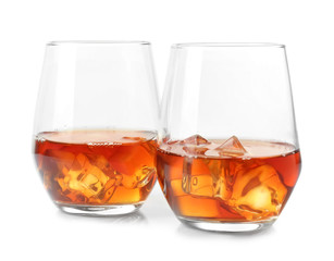 Glasses of whisky with ice on white background