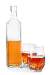 Bottle and glasses of whisky on white background