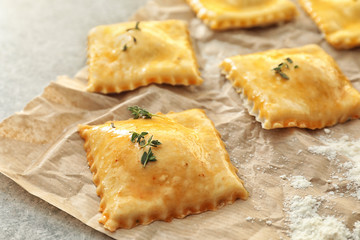 Tasty ravioli on parchment, closeup