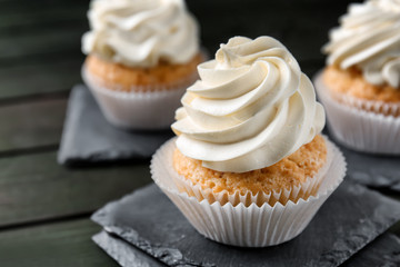 Delicious cupcakes on dark wooden table