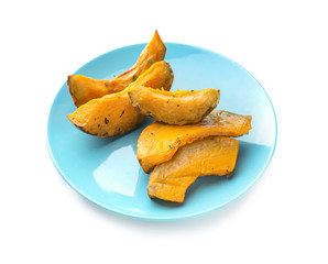 Plate with tasty baked pumpkin pieces on white background
