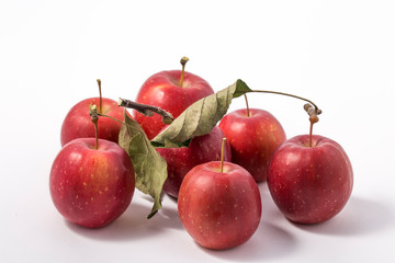 Small apple with green leaf on white background. ranetka