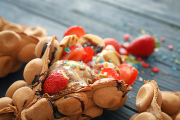 Delicious sweet bubble waffle on color wooden table