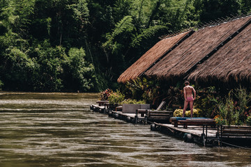 tourist sun bathing on the wooden raft in Resort home floating, river kwai at sai yok,kanchanaburi,thailand.