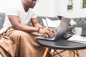 Young African American businessman remotely working at home on a laptop.