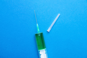 Syringe with liquid on color background